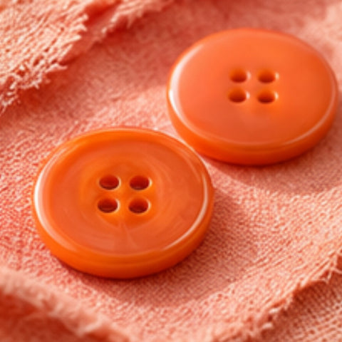Orangefarbene Knöpfe in verschiedenen Formen und Größen